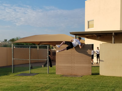 Cadet climbing over wall